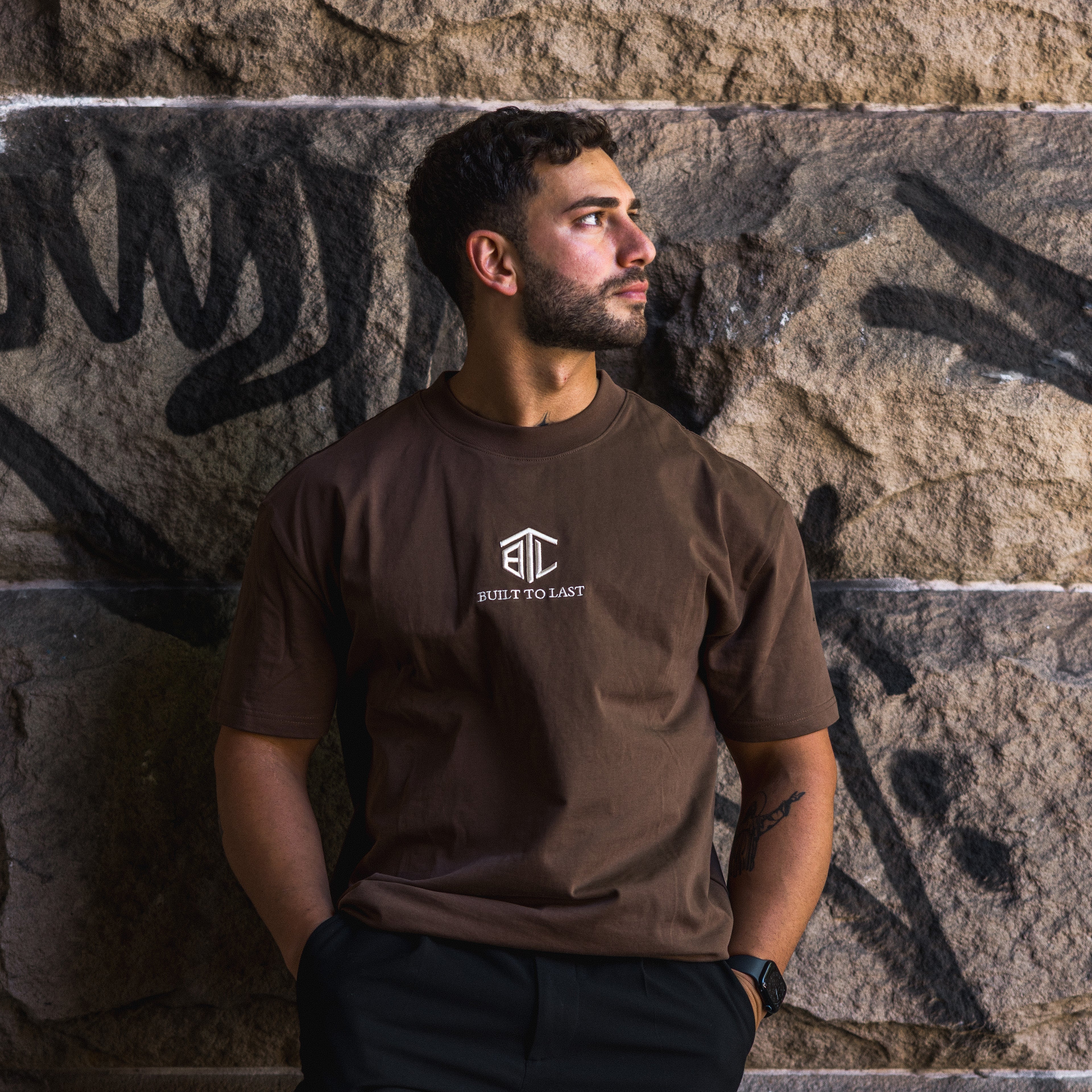 Model wearing Built to Last Eternal Tee Chocolate heavyweight cotton T-shirt with embroidered chest logo