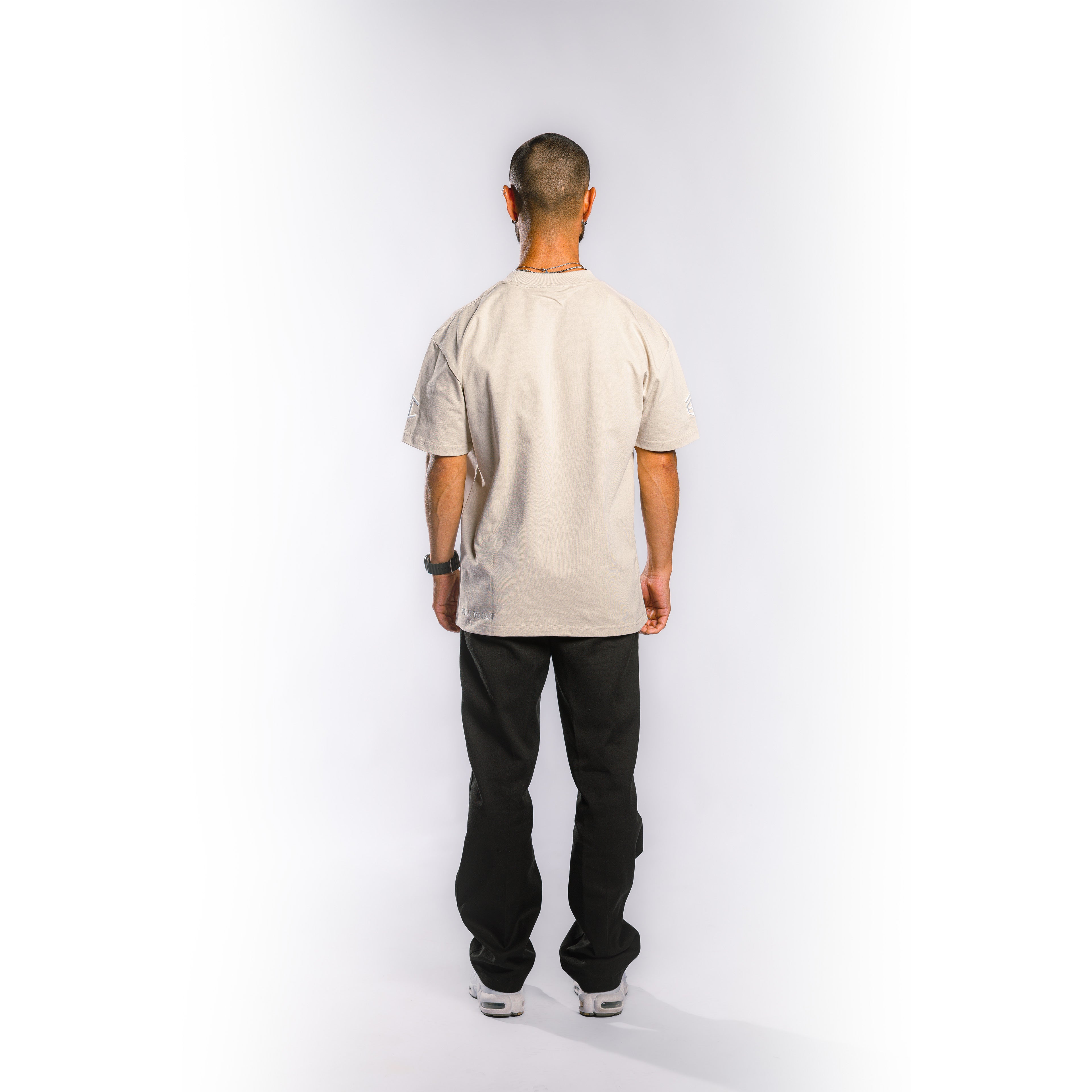 Back view of model wearing Built to Last Legacy Tee Champagne heavyweight cotton T-shirt with minimalist streetwear design