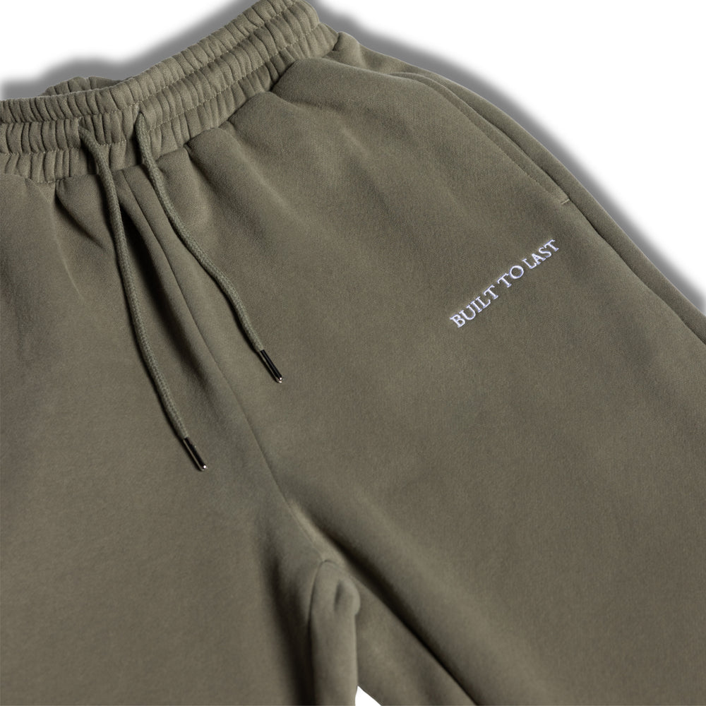 Close-up detail of waistband and logo on olive sweatpants by Built To Last.