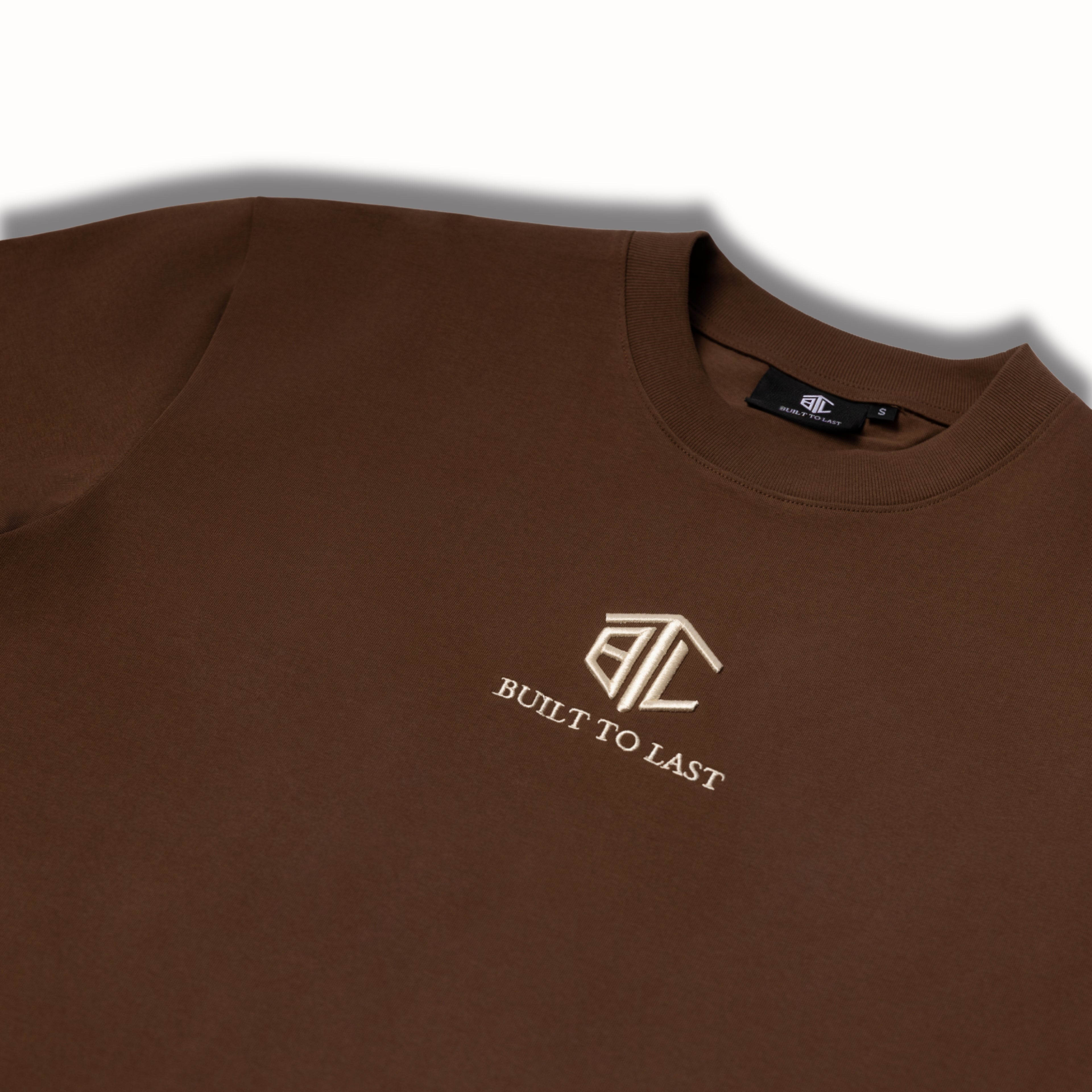 Close-up of Built to Last Eternal Tee Chocolate embroidered chest logo on premium heavyweight cotton T-shirt