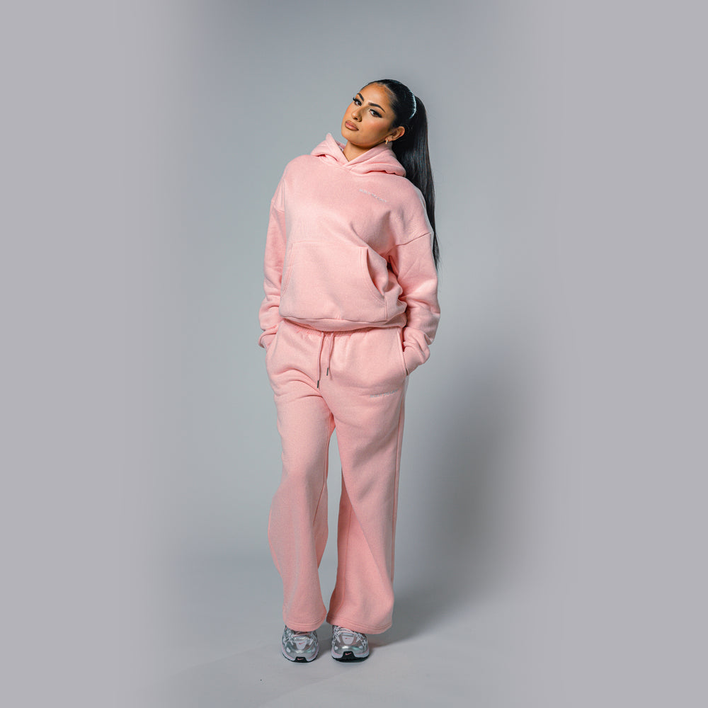 Angled view of women's light pink relaxed fit tracksuit set by Built To Last.