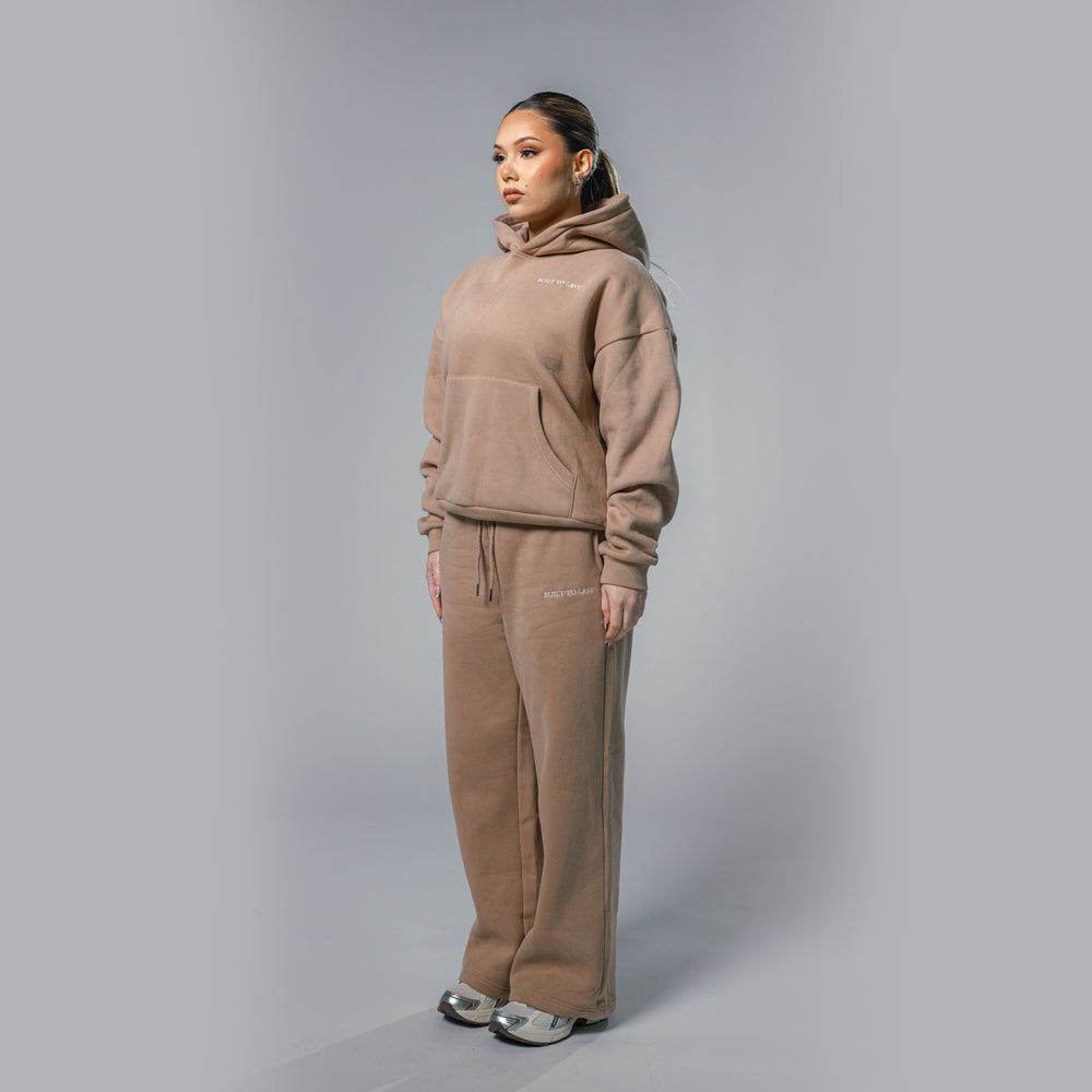 Side profile view of women's beige relaxed fit tracksuit set by Built To Last.