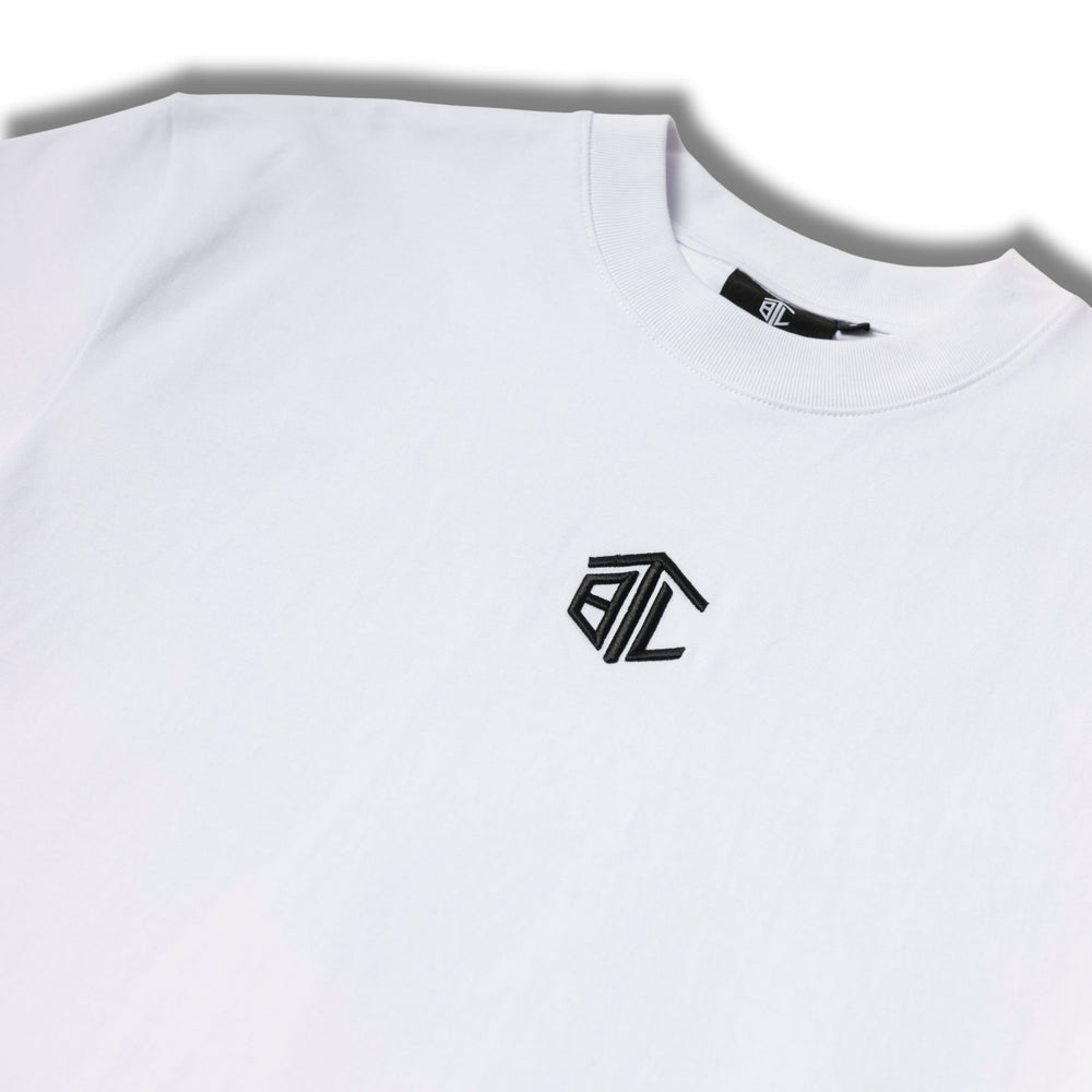 Close-up of Built to Last Monolith Tee White embroidered chest logo on premium heavyweight cotton T-shirt