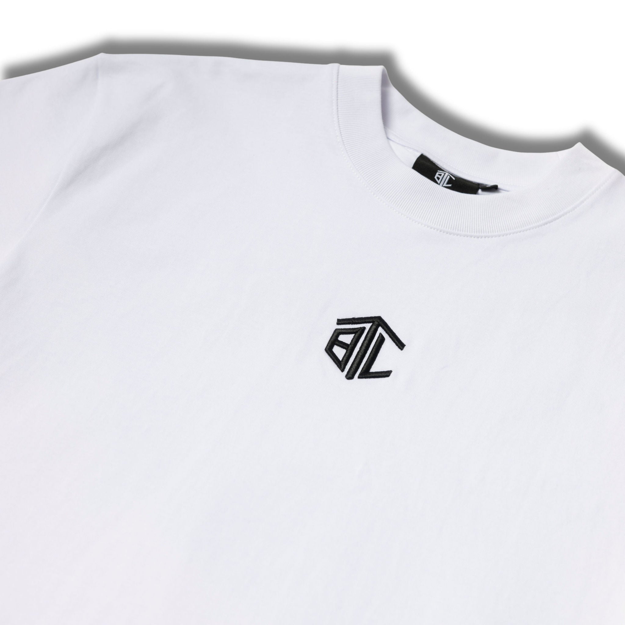 Close-up of Built to Last Monolith Tee White embroidered chest logo on premium heavyweight cotton T-shirt