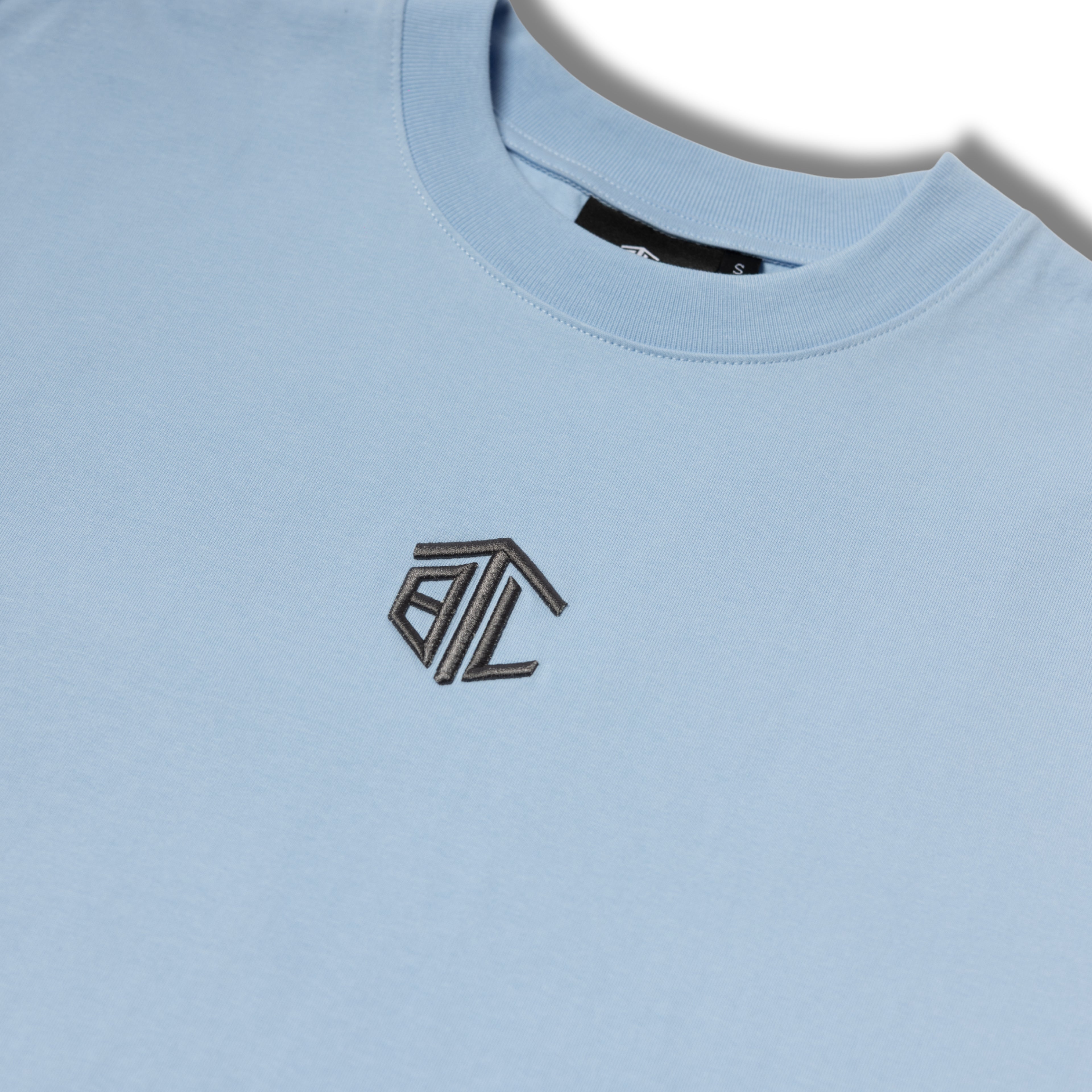 Close-up of Built to Last Monolith Tee Blue embroidered chest logo on premium heavyweight cotton T-shirt