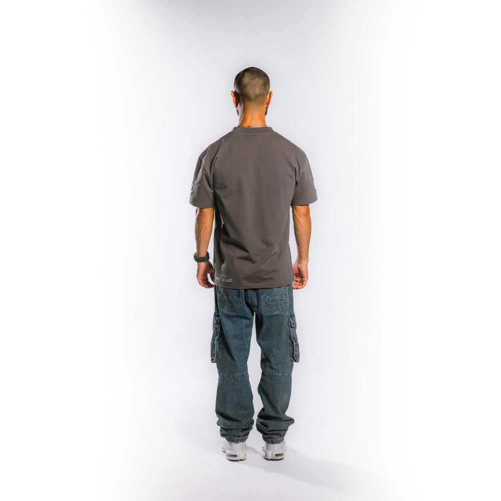 Back view of model wearing Built to Last Legacy Tee Stone heavyweight cotton T-shirt with minimalist streetwear design