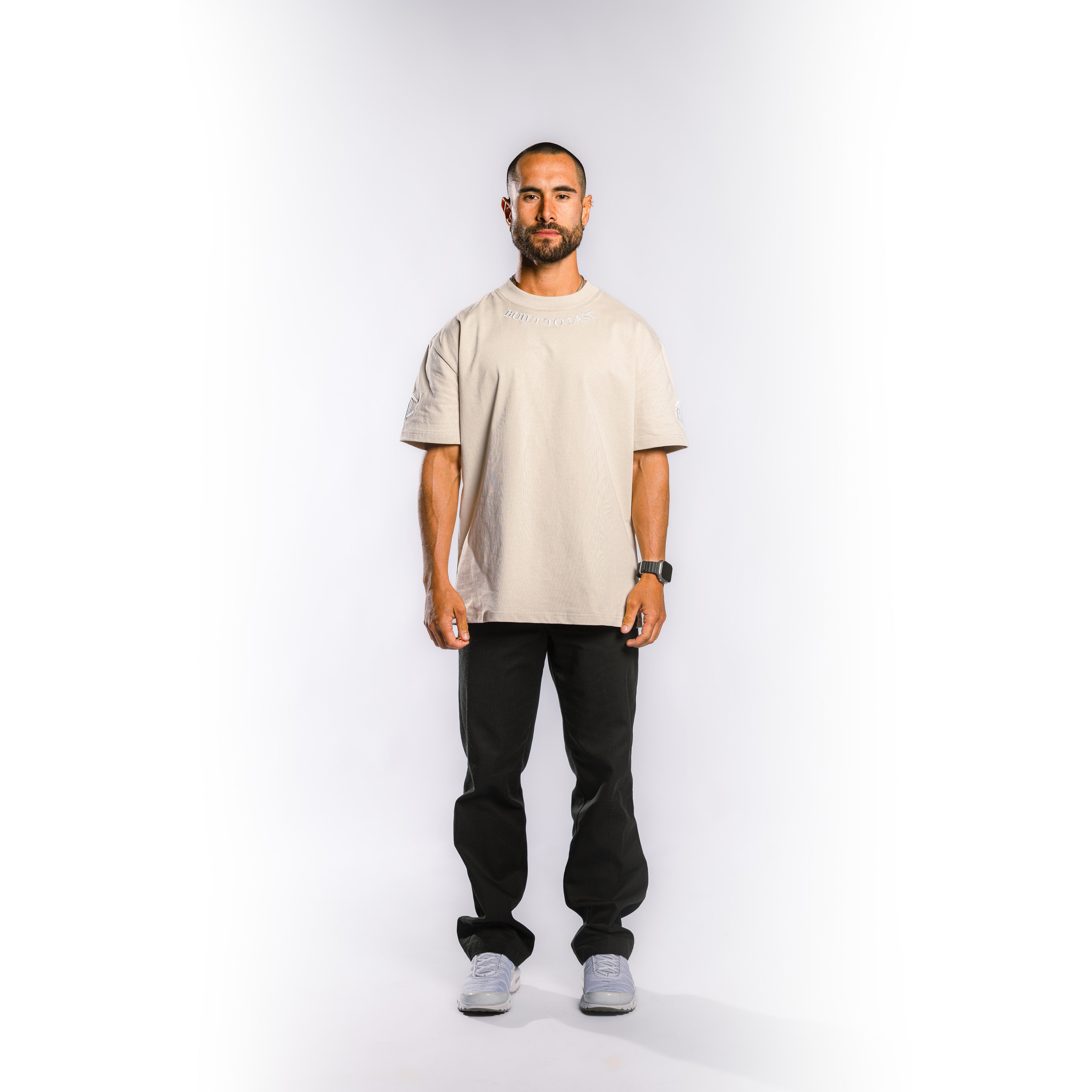 Front view of model wearing Built to Last Legacy Tee Champagne heavyweight cotton T-shirt with relaxed oversized fit
