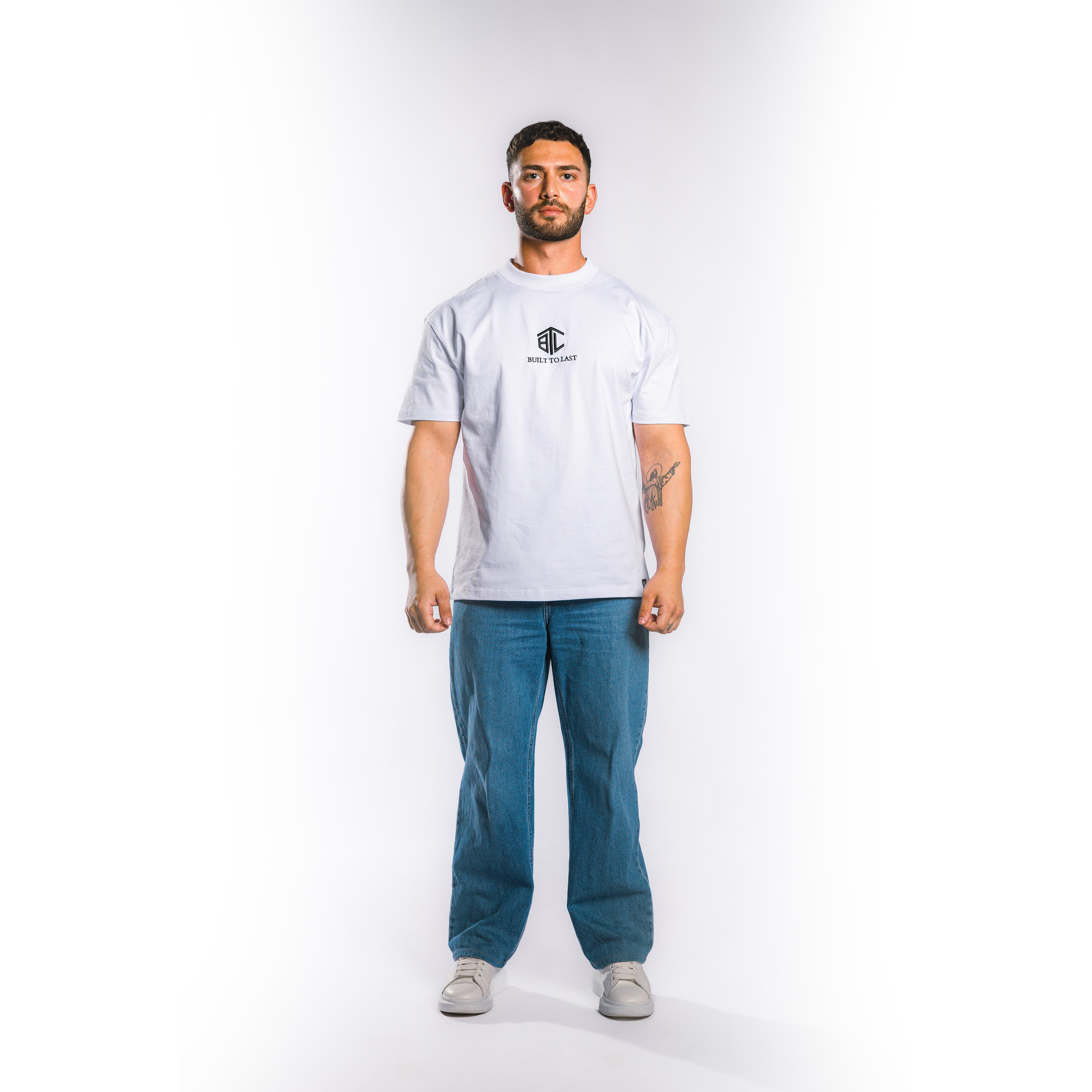 Front view of model wearing Built to Last Eternal Tee White heavyweight cotton T-shirt with embroidered chest logo