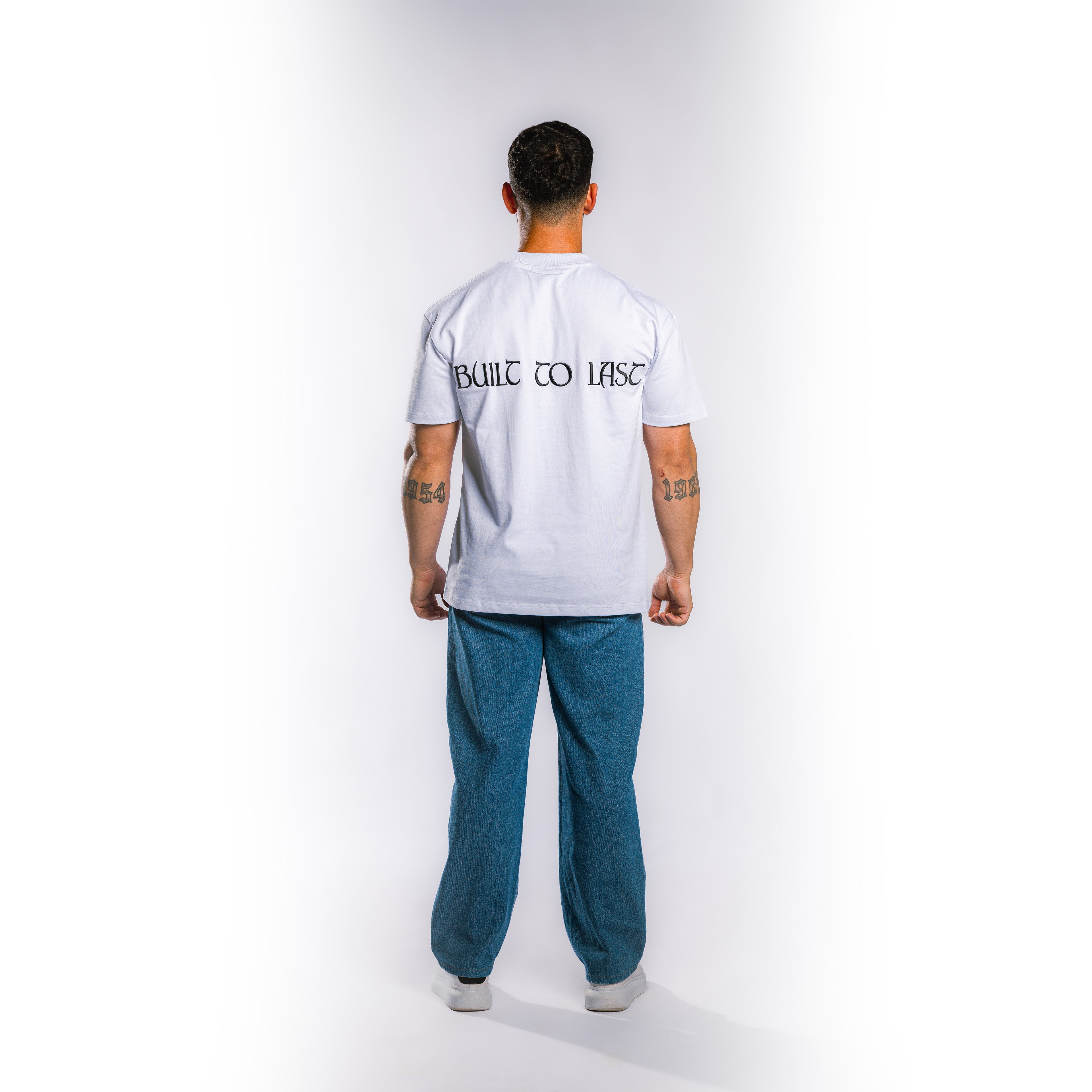 Back view of model wearing Built to Last Eternal Tee White heavyweight cotton T-shirt with embroidered Built To Last at the back