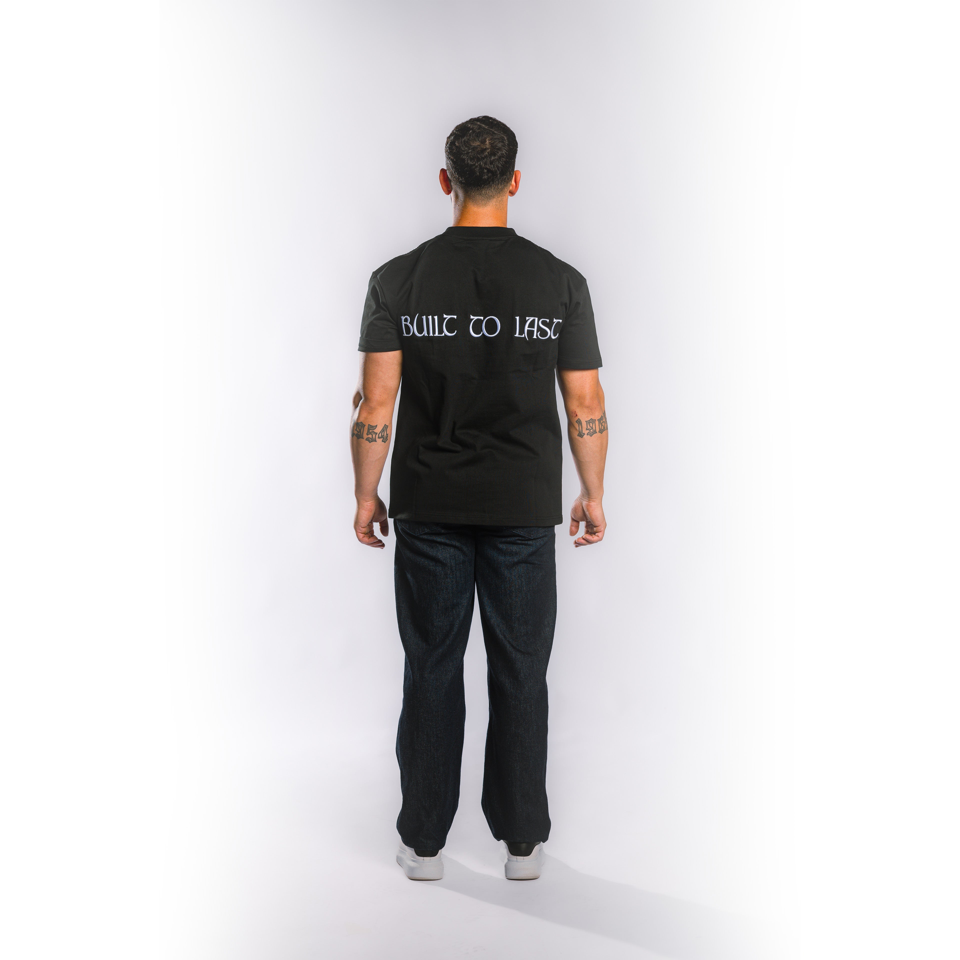 Back view of model wearing Built to Last Eternal Tee Black heavyweight cotton T-shirt with embroidered Built To Last at the back