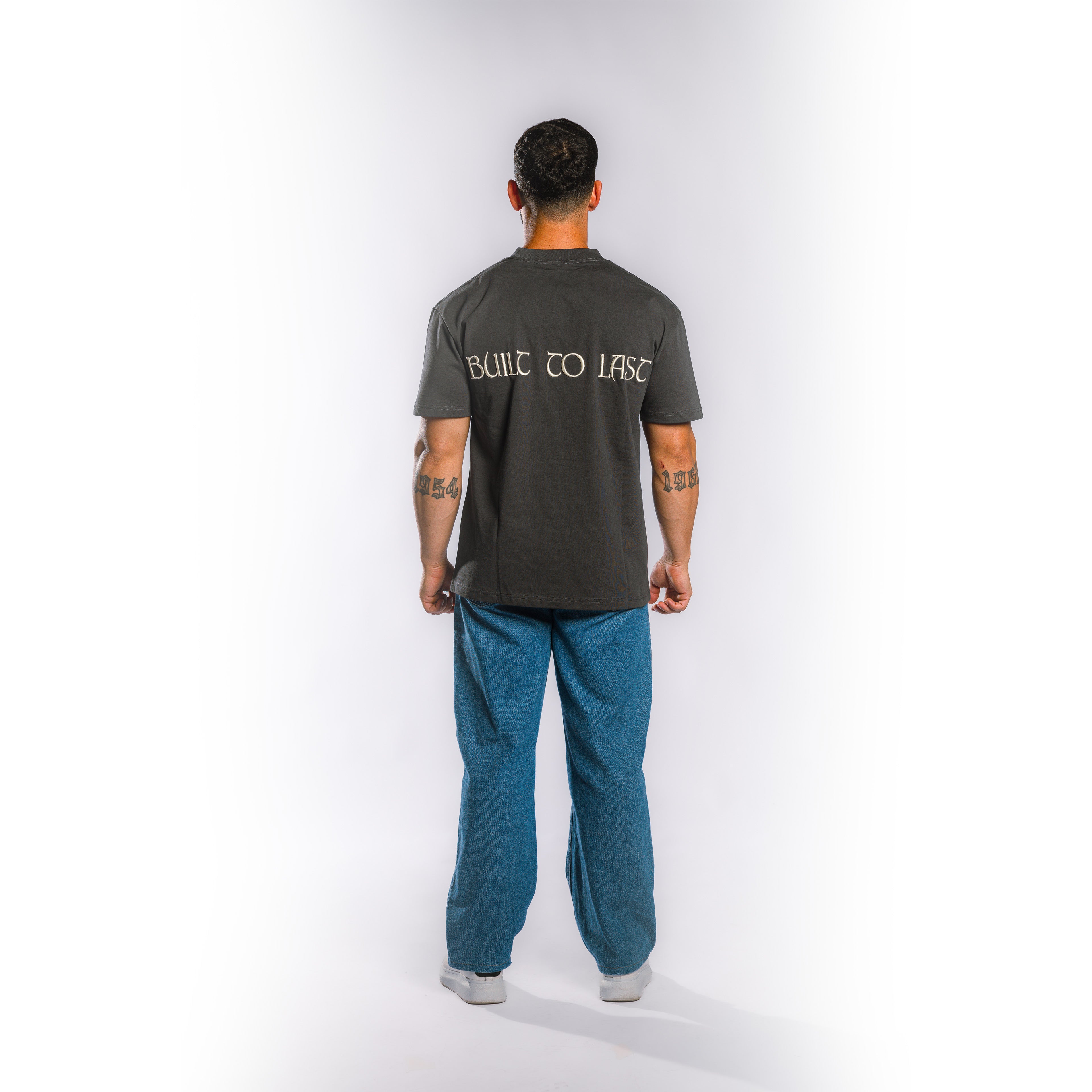 Back view of model wearing Built to Last Eternal Tee Granite heavyweight cotton T-shirt with oversized Built to Last back graphic