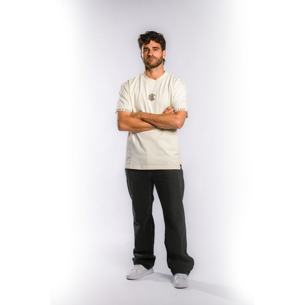 Front view of model wearing Built to Last Monolith Tee White heavyweight cotton T-shirt with embroidered chest logo and branded sleeve detail