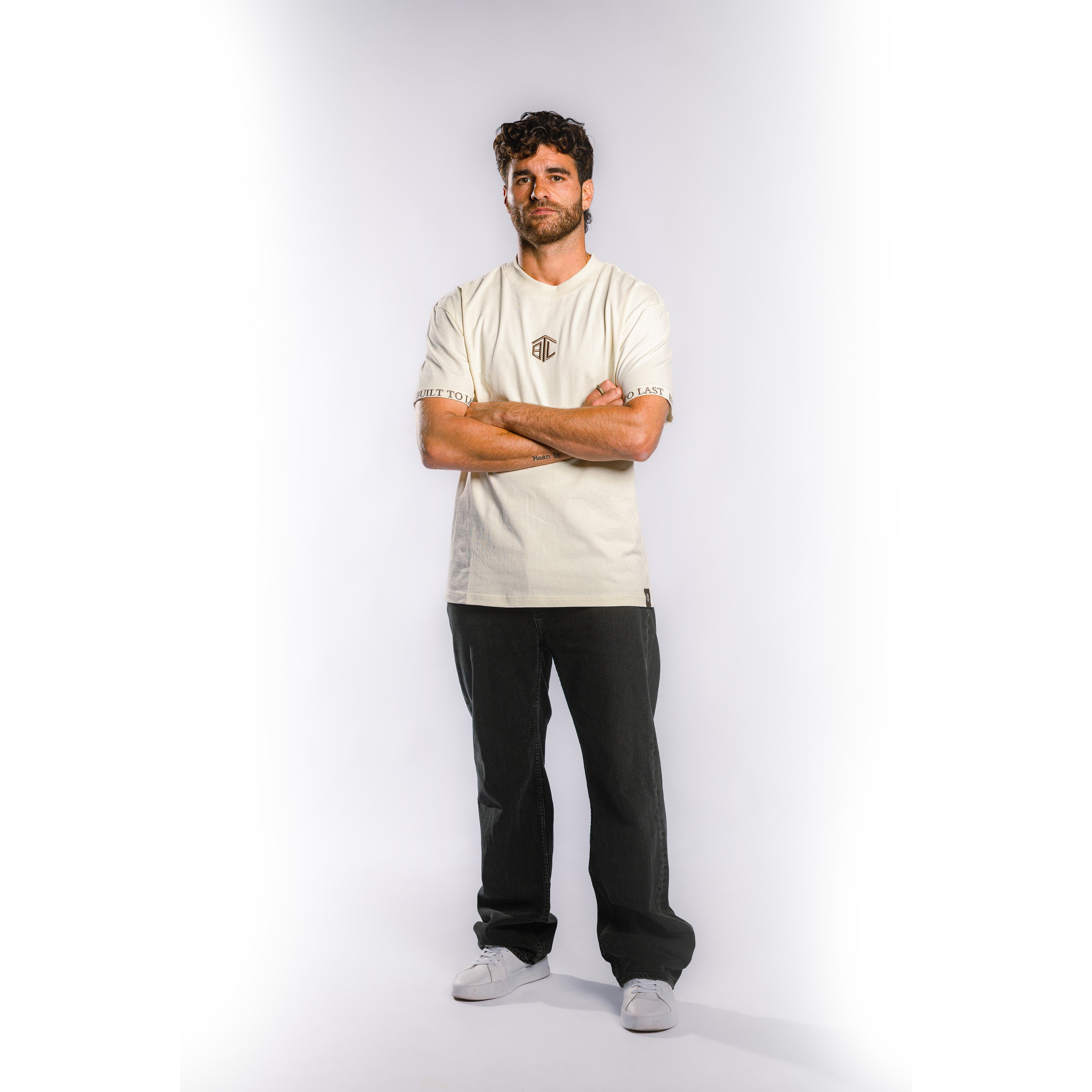 Front view of model wearing Built to Last Monolith Tee White heavyweight cotton T-shirt with embroidered chest logo and branded sleeve detail