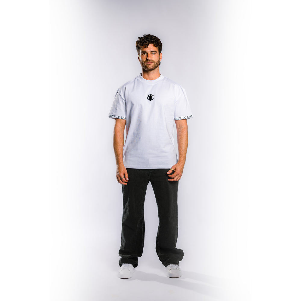 Front view of model wearing Built to Last Monolith Tee White heavyweight cotton T-shirt with embroidered chest logo and branded sleeve detail