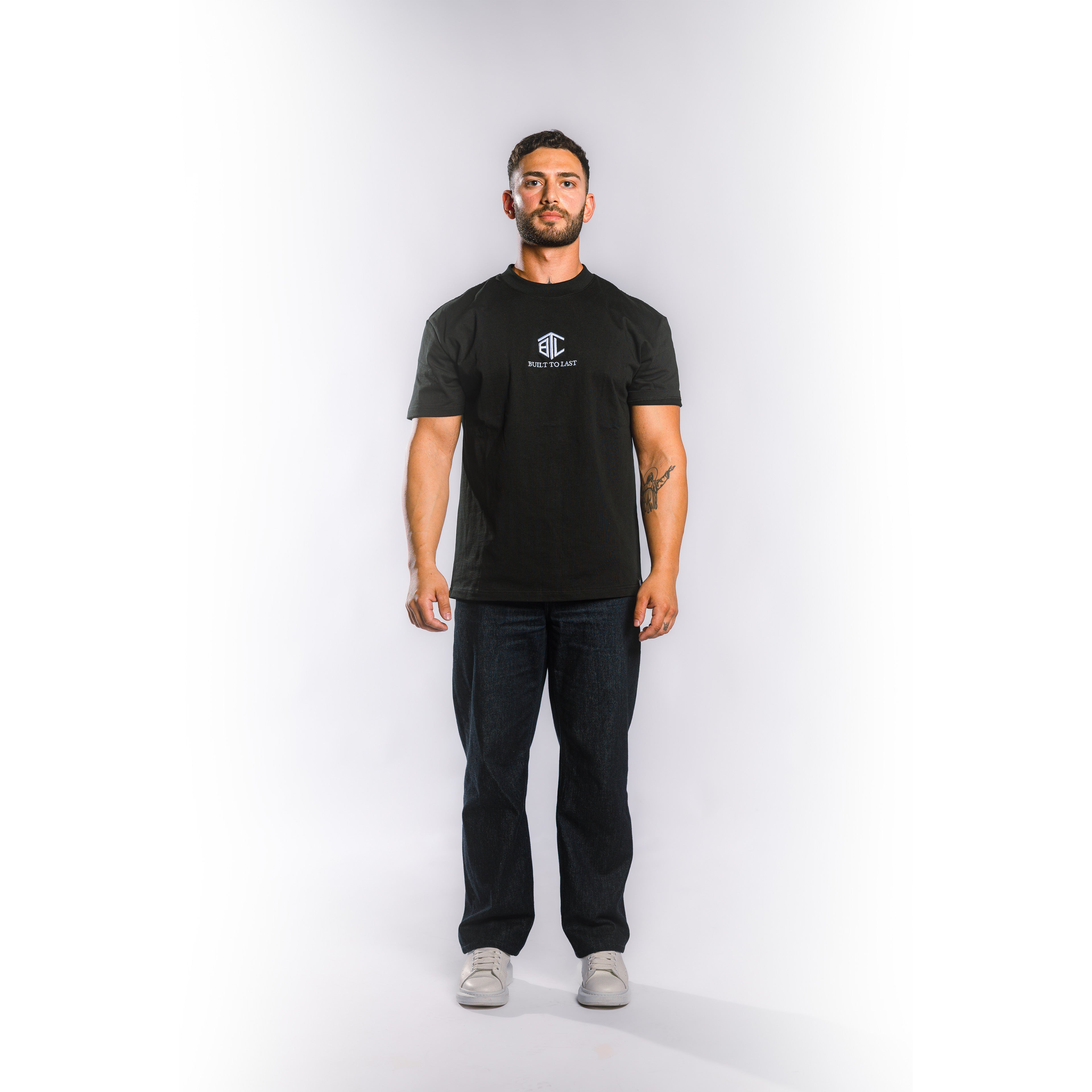 Front view of model wearing Built to Last Eternal Tee Black heavyweight cotton T-shirt with embroidered chest logo